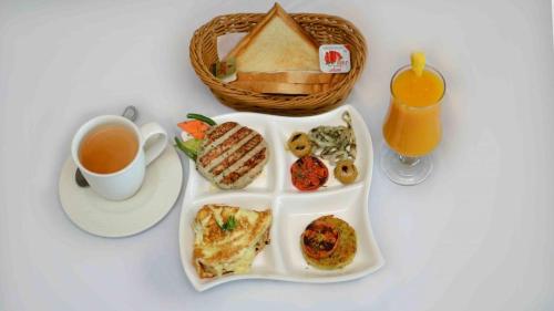 木尔坦Hotel Shaheen Continental Multan的一盘早餐食品和一杯茶