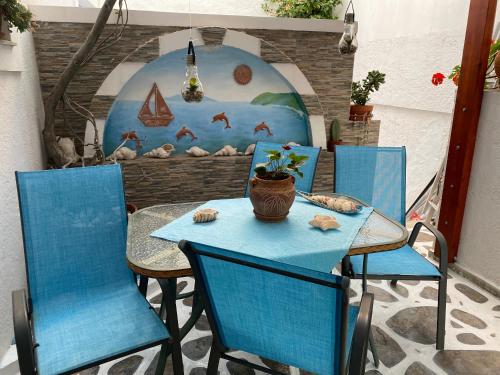 阿吉亚利Pelagos的一张桌子,上面有两把蓝色的椅子和一个花瓶