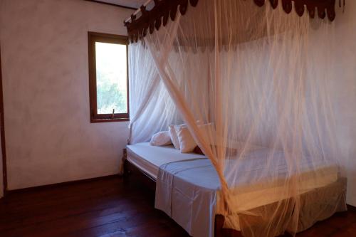 金巴兰三台巴厘岛旅馆的一间卧室配有一张带蚊帐的床
