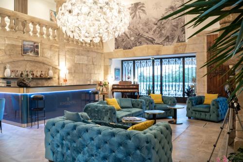 圣拉斐尔Le Confidentiel Hôtel & SPA的客厅配有蓝色的沙发和吊灯。