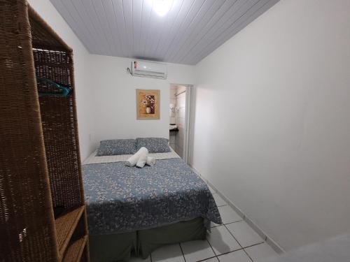 费尔南多 - 迪诺罗尼亚Pousada Água Viva的小卧室里设有一张床,上面有一只动物