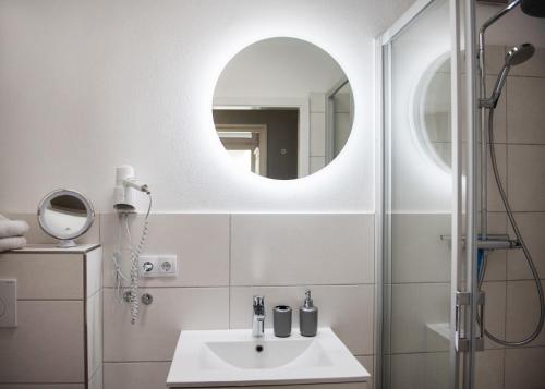 费曼城堡Strandhaus "Düne 55"的白色的浴室设有水槽和镜子