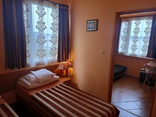 奥克宁卡"Vanilla" Pokoje i Apartamenty Nad Brzegiem Jeziora的一间小卧室,配有床和2个窗户