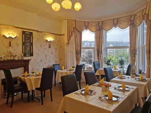 伊林港Athol Park Guest House的餐厅设有桌椅和窗户。