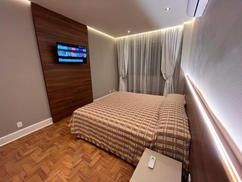 圣保罗圣拉斐尔酒店 的一间带床和电视的小卧室
