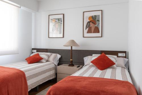 拉科鲁尼亚Luminoso apartamento en Cuatro Caminos的一间带两张床和一张沙发的卧室