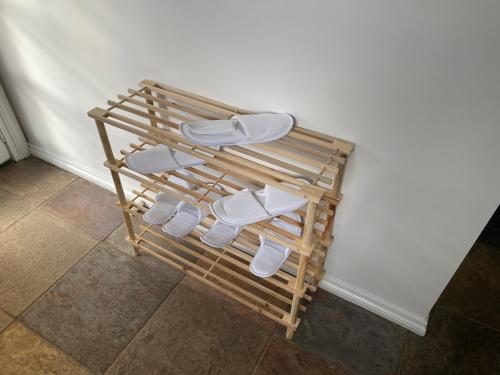 KilmoreDELIGHTFUL AND CHARMING ROSE COTTAGE的木架上的一组白色拖鞋