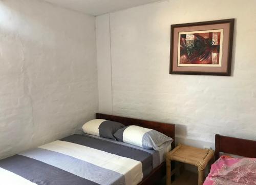 曼克拉Casa Máncora Guesthouse的卧室配有两张床,墙上挂着一幅画