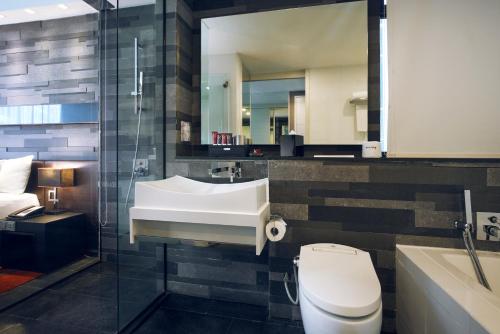新加坡Quincy Hotel Singapore by Far East Hospitality的一间带水槽、卫生间和镜子的浴室