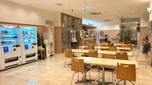 大阪Toyoko Inn Osaka Umeda Higashi的配有桌椅和自动售货机的餐厅