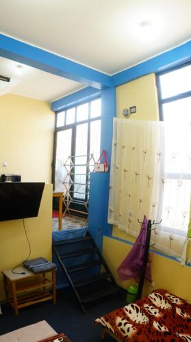 瓦拉斯Huascarán wasi, cómodo, con wifi y ducha caliente的蓝色和黄色的墙壁和窗户。