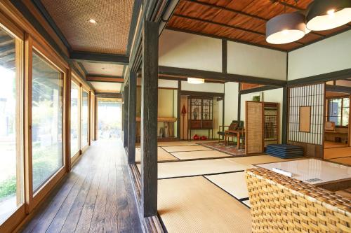 福山せとうち母家 Setouchi OMOYA的客厅铺有木地板,设有大窗户。