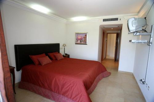 特罗亚索尔特罗亚酒店 - 福斯多佐渡的一间卧室配有红色的床和电视