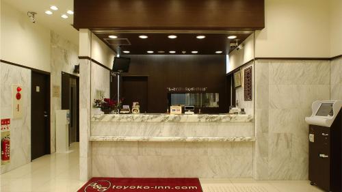 大阪Toyoko Inn Osaka Tsuruhashi Ekimae的大堂设有带大镜子的美发沙龙