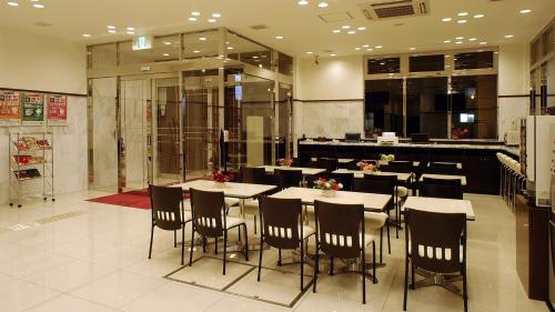 大阪Toyoko Inn Osaka Tsuruhashi Ekimae的大楼内带桌椅的餐厅