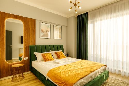马马亚Lago Apartment Mamaia Butoaie的一间卧室配有一张大床和绿色床头板