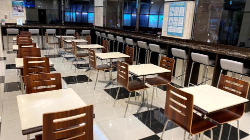 东京东横INN东京赤羽站东口的自助餐厅里一排桌椅