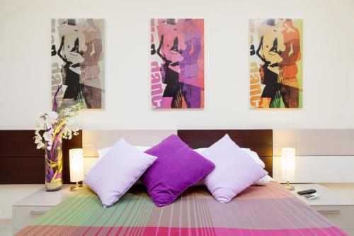 罗马Deseo Depandance的一间卧室配有一张带紫色和白色枕头的床