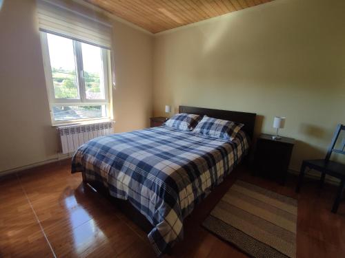Castillo-PedrosoCasa Rural La Rasilla的一间卧室配有一张带铺着地毯的床和窗户。