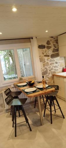 尼姆LE COSY Joli F2 proche gare, Arénes avec terrasse privée的厨房配有一张桌子和椅子,厨房设有石墙