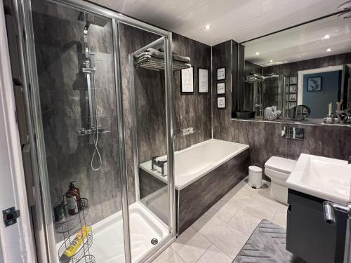 巴洛赫Loch Lomond Mews的带淋浴、浴缸和盥洗盆的浴室