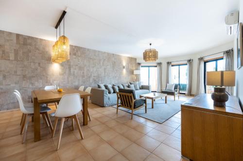 卢斯Aum Praia da Luz Resort Apartment的客厅配有沙发和桌椅