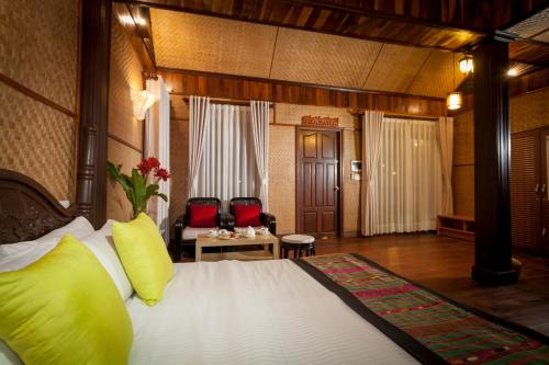 万象尚达拉精品酒店的酒店客房配有一张带黄色枕头的床
