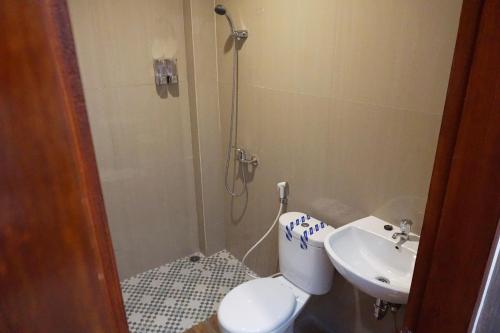 TjakranegaraLombok Mayura Hotel的带淋浴、卫生间和盥洗盆的浴室