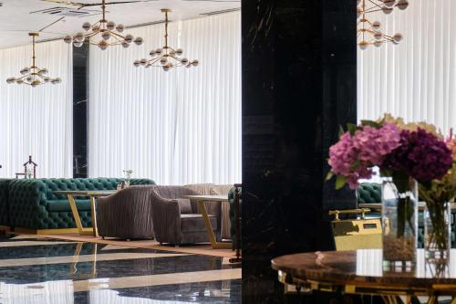 塔什干Panarams Tashkent Hotel, a member of Radisson Individuals的带沙发、桌子和鲜花的客厅