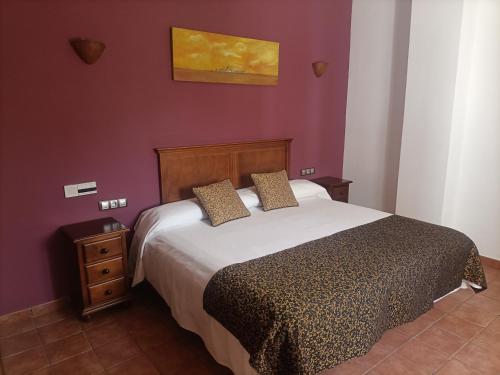 GaleraHotel Galera的一间卧室配有一张床和紫色的墙壁