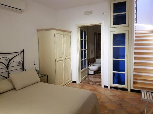 陶尔米纳Giasone Apartments的一间卧室配有一张床,浴室设有卫生间
