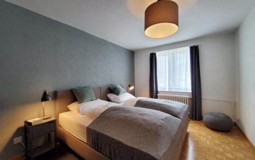圣莫里茨Apartment Via Surpunt - Perspektiva - 5 Rooms的一间卧室设有两张床和大窗户