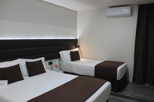 巴塞罗那BCN Urbaness Hotels Del Comte的酒店客房设有两张床和窗户。