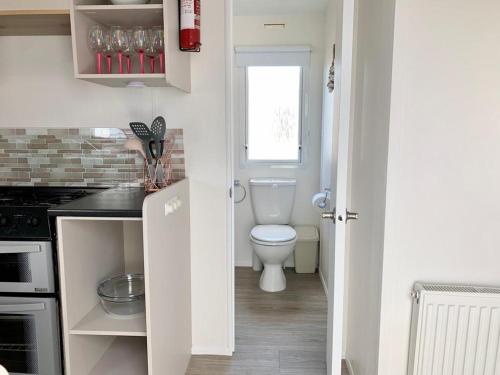 阿贝尔格莱Kens caravan的白色的浴室设有卫生间和水槽。