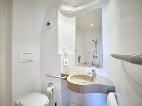 瓦勒德勒伊鲁昂南部勒伊谷基里亚德酒店的白色的浴室设有水槽和卫生间。