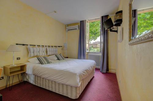 奥朗日圣让酒店的一间卧室设有一张大床和一个窗户。