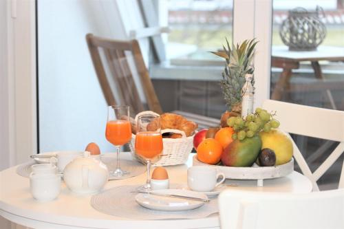 青斯特KranichSuite - Zingst的一张桌子,上面放着一碗水果和橙汁