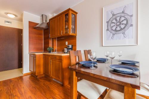 斯蒂格纳Flatbook Apartamenty - Port Stegna的一间带桌子的用餐室和一间厨房