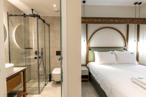 干尼亚艾尔格列柯酒店的带淋浴和床的卧室以及浴室。