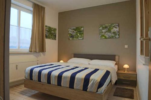 卡尔斯哈根Fewo De luette Moew_KOC的一间卧室配有一张带蓝白条纹毯子的床