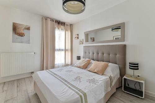 巴黎格莱莫公寓的白色卧室设有一张大床和镜子