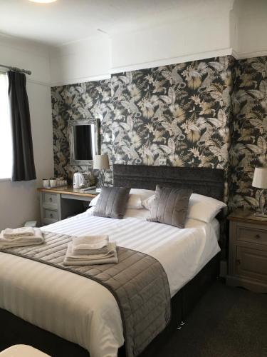 兰迪德诺肯莫尔旅馆的一间卧室配有一张带花卉壁纸的大床