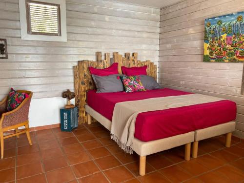 勒迪亚芒VILLA DIAMANTILLES - MAISON D'HOTES的一间卧室配有一张大床和木制床头板