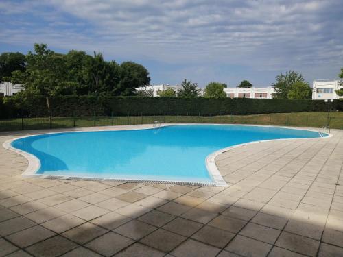 第戎Romantisme et glamour avec spa, piscine et jardin的大型蓝色游泳池,设有瓷砖庭院