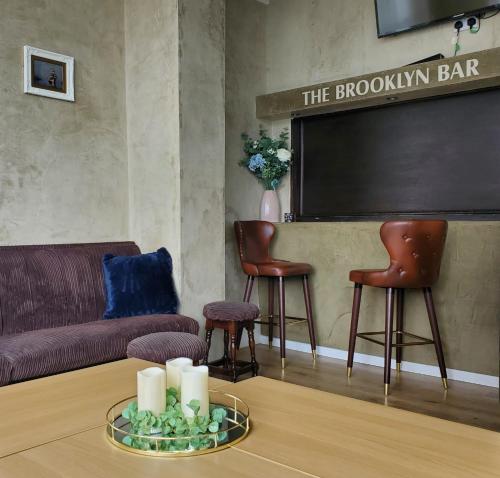 布莱克浦布鲁克林酒店的带沙发、椅子和黑板的客厅