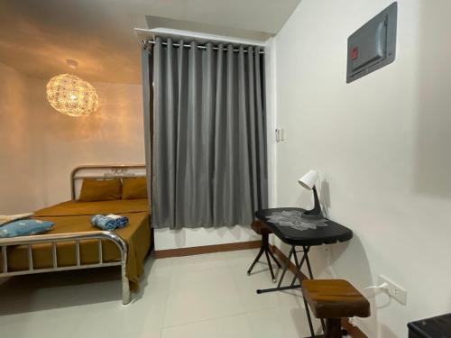卢塞纳Sto. Niño Residences Standard Room的一间卧室配有一张床、一张书桌和一个窗户。