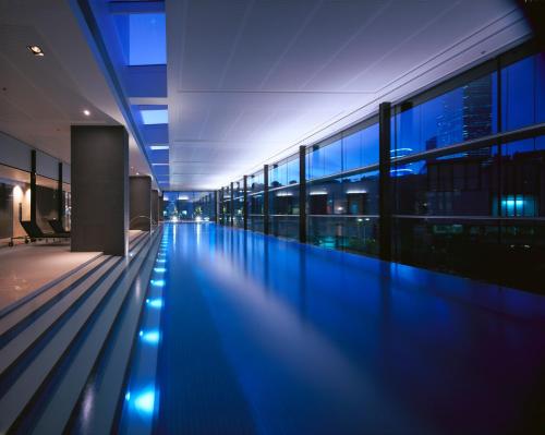 墨尔本皇冠江滨酒店的一座空的游泳池,晚上在建筑物里