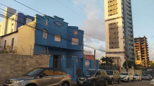纳塔尔Pousada Cisne Branco的一群停在蓝色建筑前面的汽车