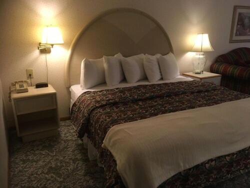 马凯特Value Host Marquette的酒店客房设有一张大床和两盏灯。
