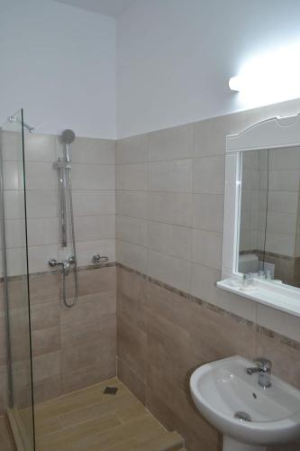 尼普顿伊恩苏拉酒店的带淋浴、盥洗盆和镜子的浴室